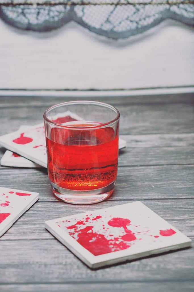 Serve your delicious drinks on these bloody coasters this Halloween! This blood-splattered coaster DIY with ceramic tiles is super easy and inexpensive!