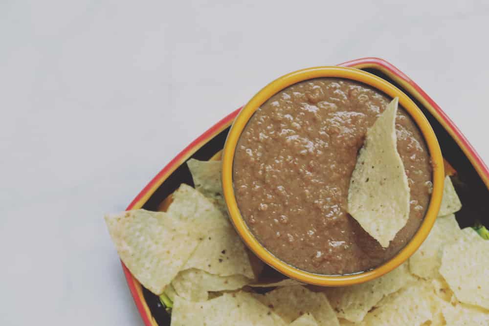 This simple slow cooker bean dip is perfect for game day snacking. Just a few ingredients and hours later you've got a deliciously easy dish!