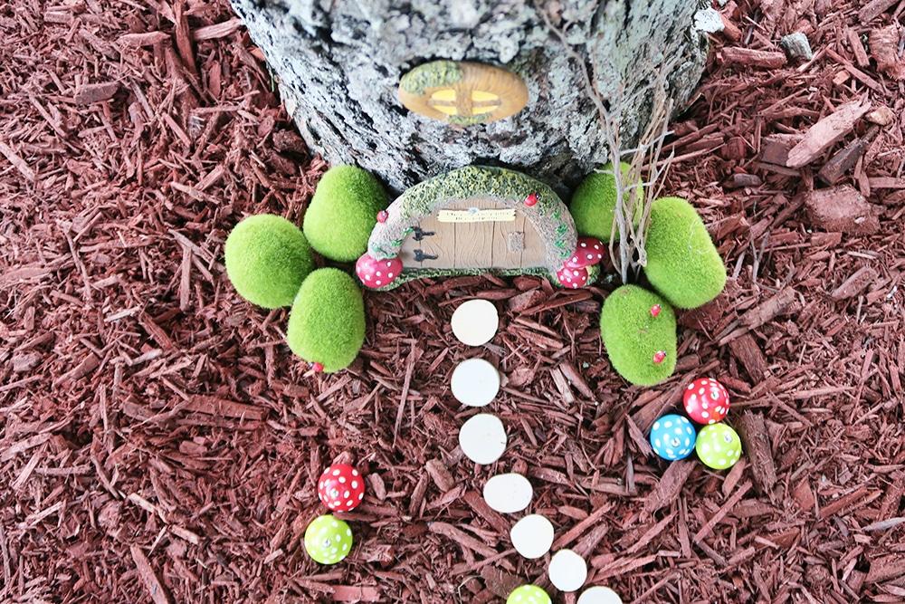 Want to add some whimsy to your yard? This simple DIY fairy garden is the answer! You'll turn your tree base into a magical scene in no time.