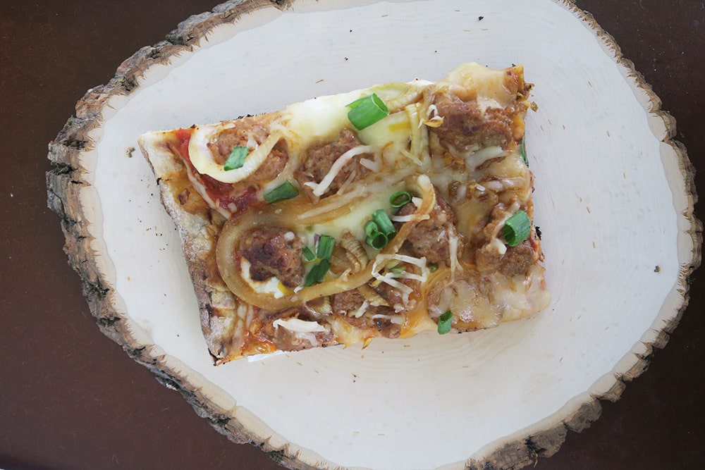 This Grilled Onion Sausage Fennel Pizza Recipe is a summer dish you won't want to miss! Made with store-bought pizza dough, dinner will be done in no time!