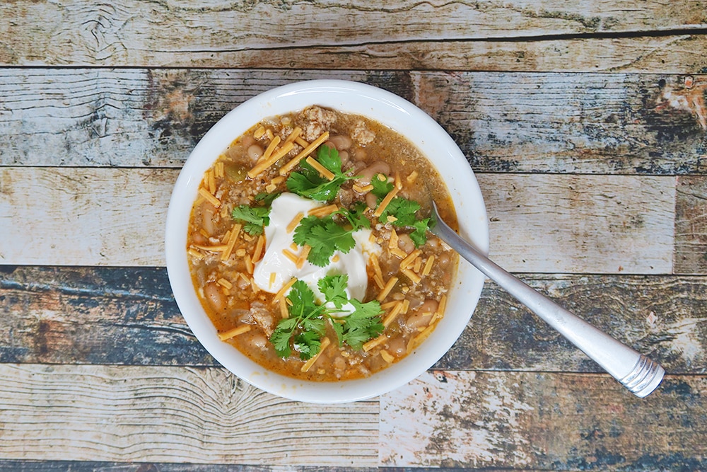 Need a hearty and healthy dish for the colder months? This Slow Cooker White Bean Turkey Chili recipe is super easy and ready in less than three hours!