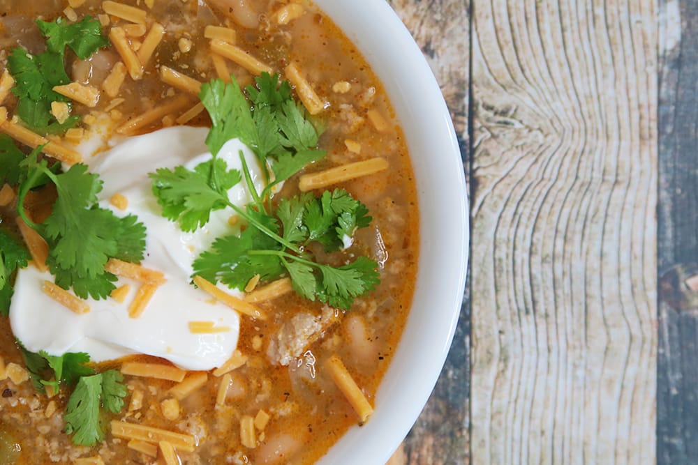 Need a hearty and healthy dish for the colder months? This Slow Cooker White Bean Turkey Chili recipe is super easy and ready in less than three hours!