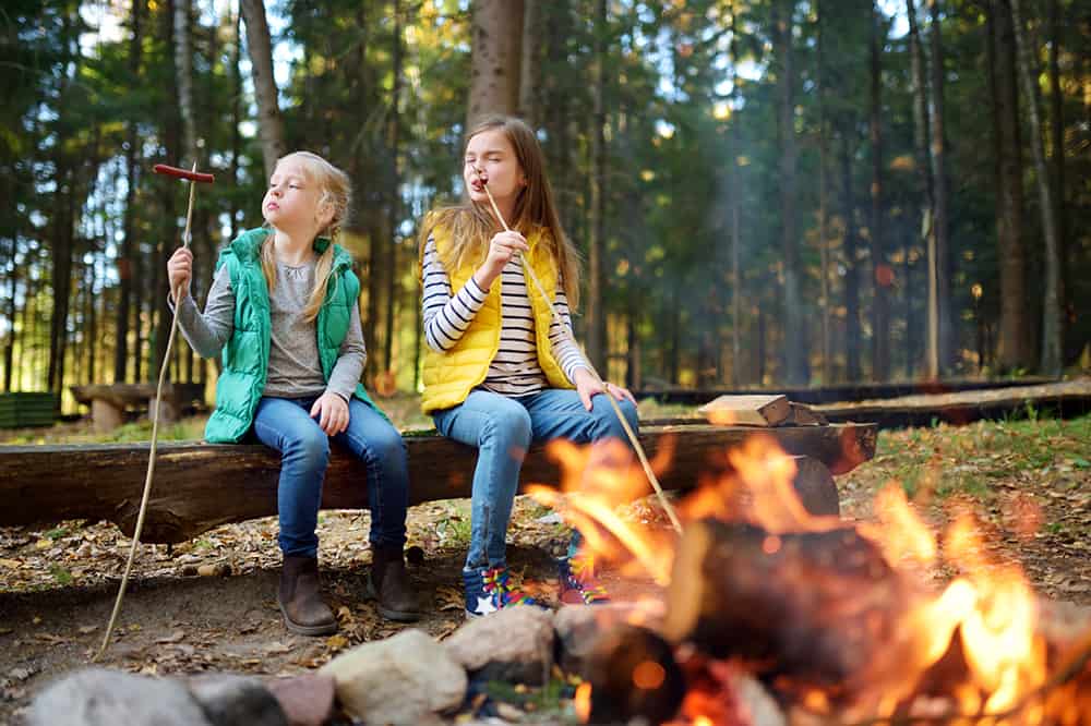 two girls by campfire